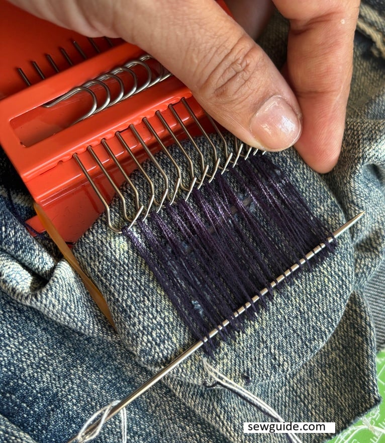 darning with the darning tool over jeans hole