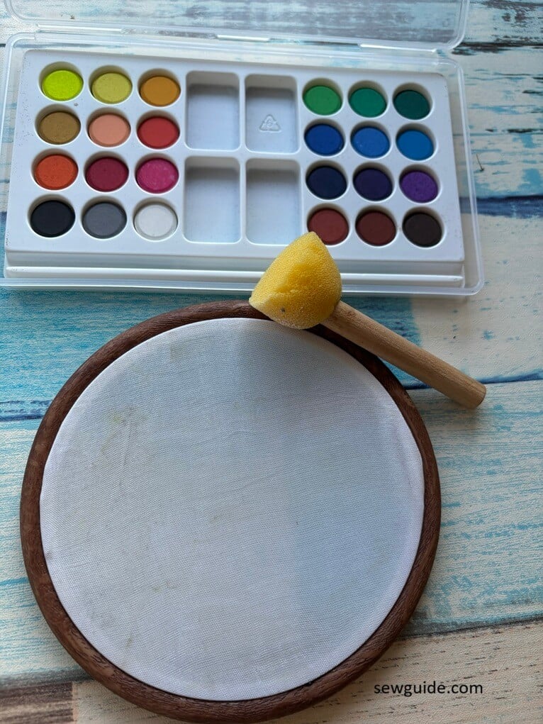 water color brush and fabric hooped